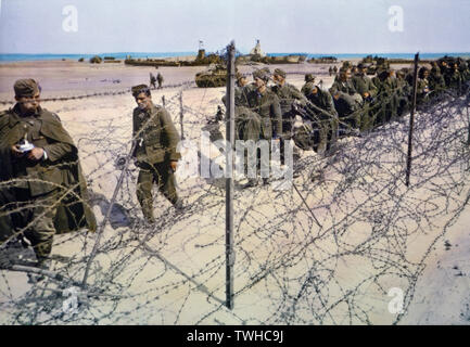Deutsche Soldaten gehalten in Stacheldraht Gehäuse am Strand während der Invasion in der Normandie, Frankreich, Juni 1944 erfasst Stockfoto