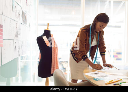 Weibliche Mode Designer Zeichnung Skizze auf dem Tisch in einem modernen Büro Stockfoto
