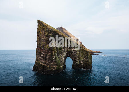 Nahaufnahme der berühmten Drangarnir Klippe mit Tindholmur Inseln im Hintergrund, während Sie am frühen Morgen Wanderung im Frühling gemacht (Färöer Island, Dänemark) Stockfoto