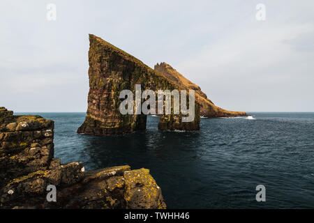 Nahaufnahme der berühmten Drangarnir Klippe mit Tindholmur Inseln im Hintergrund, während Sie am frühen Morgen Wanderung im Frühling gemacht (Färöer Island, Dänemark) Stockfoto