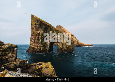 Nahaufnahme der berühmten Drangarnir Klippe mit Tindholmur Inseln im Hintergrund, während Sie am frühen Morgen Wanderung im Frühling gemacht (Färöer Island, Dänemark) Stockfoto