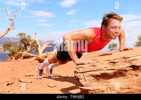 Fitness-wettkämpferin mann Ausbildung Push-ups in atemberaubender Natur Landschaft. Krafttraining fit Männlich, Training im Freien im Sommer tun Neigung push-up. Stockfoto