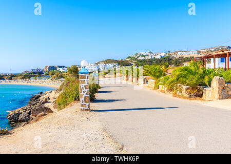Küstenstraße mit Palmen und bunten Häusern entlang der wunderschönen Meer bei ammopi Strand, Insel Karpathos, Griechenland Stockfoto
