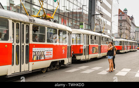 Prag, tschechische Republik - AUGUST 2018: Straßenbahnen Queuing in Prag Stadtzentrum blockiert zwei Menschen auf der Straße an einem fußgängerüberweg zu überqueren. Stockfoto