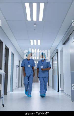 Chirurgen miteinander reden während des Gehens in der Flur am Krankenhaus Stockfoto