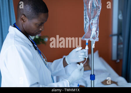 Männlicher Arzt Injektion Injektion zu weiblichen Patienten intravenöse Tropfinfusion in der Gemeinde Stockfoto