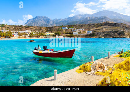 Boot auf dem Meer im Ort Lefkos Port mit fischernetze am Ufer, Karpathos, Griechenland Stockfoto
