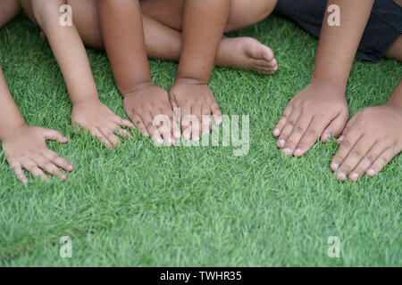 Die Arme des Kindes auf dem grünen Rasen Stockfoto