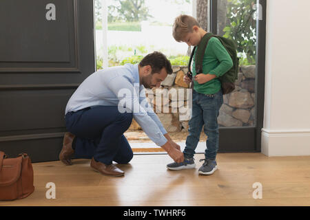 Vater seine Söhne Schnürsenkel binden in ein gemütliches Heim Stockfoto