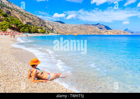 Junge Frau, die sich in Wasser auf Apella Strand, Insel Karpathos, Griechenland Stockfoto