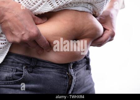 In der Nähe von Frau drückende Bauch Fett mit Ihren beiden Händen Stockfoto