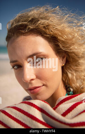 Schöne Frau in ein Handtuch eingewickelt stehen am Strand Stockfoto