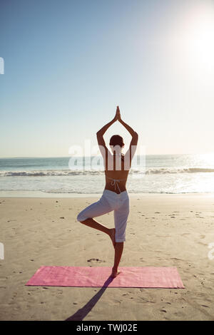 Frau durchführen Yoga am Strand Stockfoto