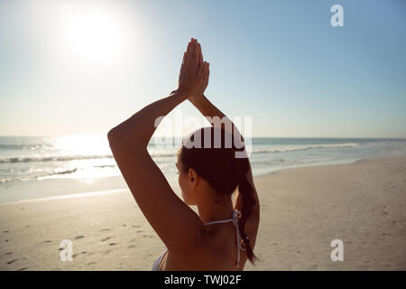 Frau durchführen Yoga am Strand Stockfoto