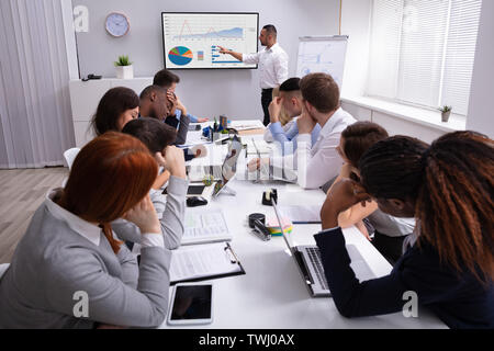 Gruppe von Führungskräften müde vom langen Sitzung im Amt Stockfoto