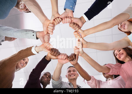 Multi-ethnischen Gruppe von Menschen, die einander Daumen bilden Kreis Stockfoto