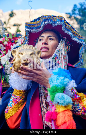 Choqueklka Festival Prozession. Frau mit Señor de Choqueklka Bild, Peruanischen Heiligen Tal der Inkas Stadt Ollantaytambo, Peru. Stockfoto