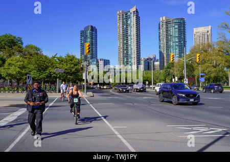 Toronto, Kanada - 06 23 2019: Fußgänger und Radfahrer Überqueren der Straße auf dem Lake Shore Boulevard West und Strachan Avenue Kreuzung vor neue Stockfoto