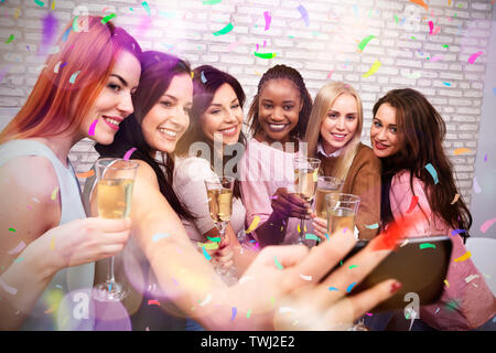 Gerne Frauen mit Champagner und Smartphone unter Selfie bei Nacht Club Stockfoto