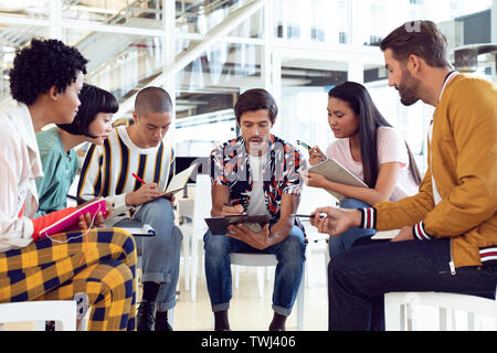 Business Leute zusammen sitzen und in der Gruppe Diskussion im Büro Stockfoto