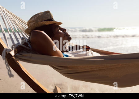 Mann mit Hut schlafen in der Hängematte am Strand Stockfoto