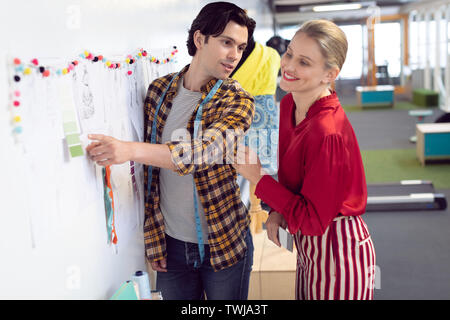 Männliche und weibliche Mode Designer diskutieren über Skizze Stockfoto