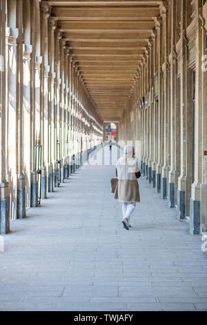 Paris, Frankreich - 12 April, 2019: ältere Frau mit beige Kleidung Wandern im Palais-Royal Kolonnade Stockfoto