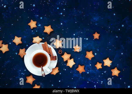 Astronomie und Konstellation flach mit kopieren. Teatime mit sternförmigen Cookies. Weißes Porzellan Tassen auf einen Sternenhimmel Hintergrund. Stockfoto