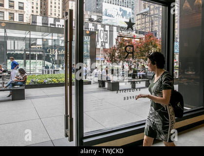 New York, 6/6/2019: Die Szene auf dem Broadway in Midtown Manhattan als von innen ein Starbucks Coffee shop buchen. Stockfoto