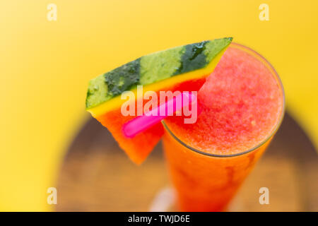 Gesunde Wassermelone Smoothie in Glas mit Wassermelone und Stroh auf gelben Hintergrund, gesunden Entgiftung oder Diät Konzept Stockfoto