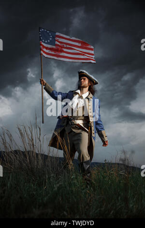 Amerikanische Revolution Krieg Soldat mit Flagge von Kolonien über dramatische Landschaft. 4. Juli, Tag der Unabhängigkeit der USA Konzept Fotomontage: Soldat und f Stockfoto