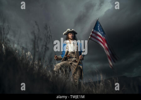 Amerikanische Revolution Krieg Soldat mit Flagge von Kolonien und Sabre über dramatische Landschaft. 4. Juli, Tag der Unabhängigkeit der USA Konzept Fotomontage: Sol Stockfoto