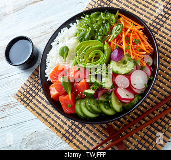 Raw Organic Ahi lachs Poke Schüssel mit Reis, Seetang, Avocado Rose, Rettich, Karotten, Gurken, grüner Salat, bestreut mit Frühlingszwiebeln und Sesam se Stockfoto