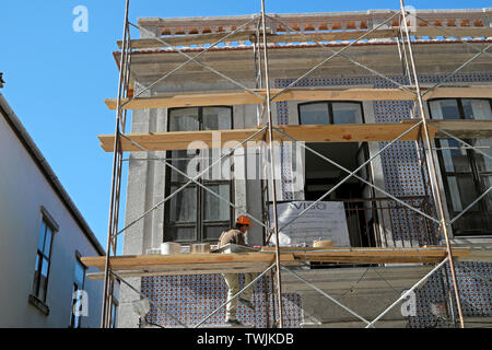 Arbeitnehmer arbeiten auf einer Baustelle arbeiten auf Fliesen Modernisierung der Fassade eines Hauses in Porto Portugal Europa EU-KATHY DEWITT Stockfoto