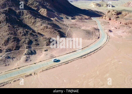 Einziges Auto auf einem alten Wüste Straße, Antenne folgen Bild. Stockfoto
