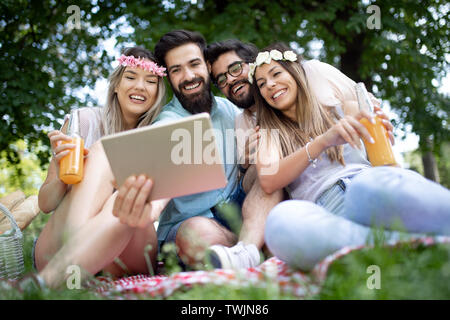 Glückliche junge Freunde unter selfies auf ein Picknick im Freien Stockfoto