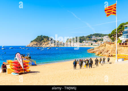 TOSSA DE MAR, SPANIEN - Jun 3, 2019: Taucher zu Fuß am Strand in der Stadt Tossa de Mar, Costa Brava, Spanien. Stockfoto