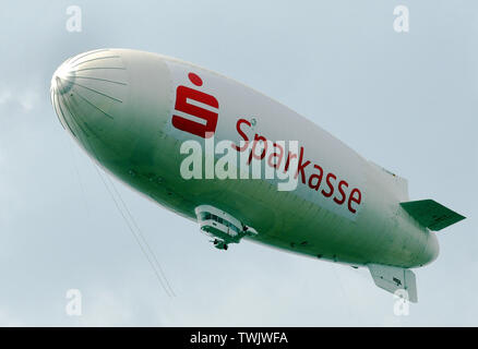 Düsseldorf, Deutschland. Juni, 2019 18. Das luftschiff Theo mit dem Banner Sparkasse reist über die Landeshauptstadt. Credit: Horst Ossinger/dpa/Alamy leben Nachrichten Stockfoto