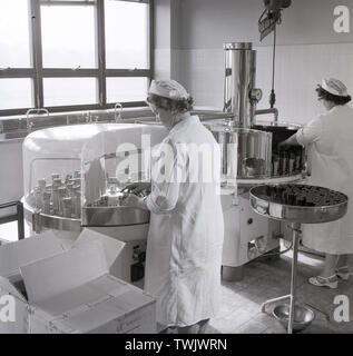 1950, historische, weibliche Lab techncians in whitecoats innen an der Sandoz industrial Fabrik in Horsforth, Leeds, England, UK. Die Fabrik produziert Chemcials und Farbstoffe für den Einsatz in Textilien, Leder und Papier und im Jahr 1995 wurde die Clariant Chemische Werke umbenannt. Stockfoto