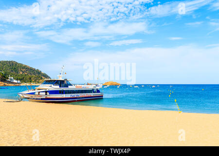 TOSSA DE MAR, SPANIEN - Jun 3, 2019: Touristische Schiff Verankerung am goldenen Sandstrand von Lloret de Mar, Costa Brava, Spanien. Stockfoto