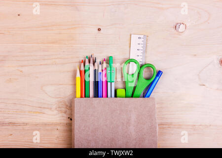 Schule Konzept. Buntstifte, Schere, Lineal, Zirkel in eine braune Papiertüte Stockfoto