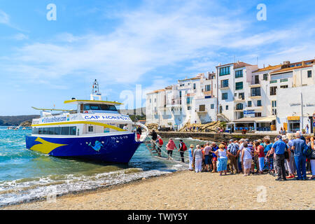 CADAQUES, SPANIEN - Jul 4, 2019: Touristen warten am Strand für Schiff, das tägliche Fahrten zu den Rosen port von Cadaqués, Costa Brava, Spanien. Stockfoto