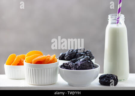 Konzept gesunde Ernährung, Vegetarismus Ernährung. Joghurt, getrocknete Aprikosen und Pflaumen in einem weißen Schalen. Stockfoto