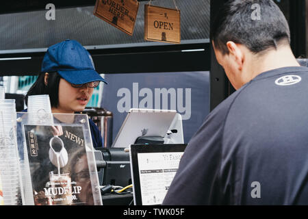 London, UK, 15. Juni 2019: Mann kaufen Taiwan Obst Tee aus Yi Fang stall in Spitalfields Market, einem der schönsten viktorianischen Märkten in London Stockfoto