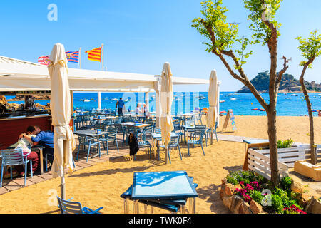 TOSSA DE MAR, SPANIEN - Jun 3, 2019: Die Menschen essen im Restaurant am Strand von Tossa de Mar, Costa Brava, Spanien. Stockfoto