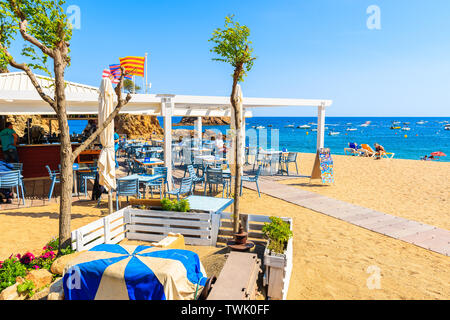 TOSSA DE MAR, SPANIEN - Jun 3, 2019: Die Menschen essen im Restaurant am Strand von Tossa de Mar, Costa Brava, Spanien. Stockfoto