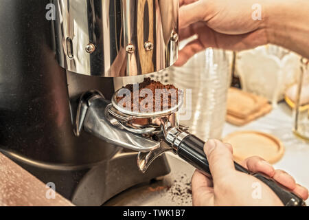 Hände halten Kaffeemühle Pulver, warmen Ton Stockfoto