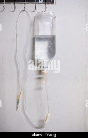 Kochsalzlösung iv-Beutel mit Spritze Linie an den weißen Wand Stockfoto