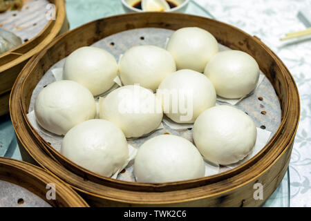 Vanillepudding lava Creme und gebratenen roten Schweinefleisch gefüllte Brötchen auf Bambus tablett auf Tabelle Stockfoto