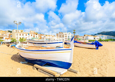 Fischerboote am goldenen Sandstrand mit weißen Häuser im Hintergrund, Tossa de Mar, Costa Brava, Spanien Stockfoto
